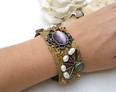 Mintook- Vintage Bracelet, with a middle  oval purple stone, pearles, metal elements and workbeads, all stitched to a ribbon lace.