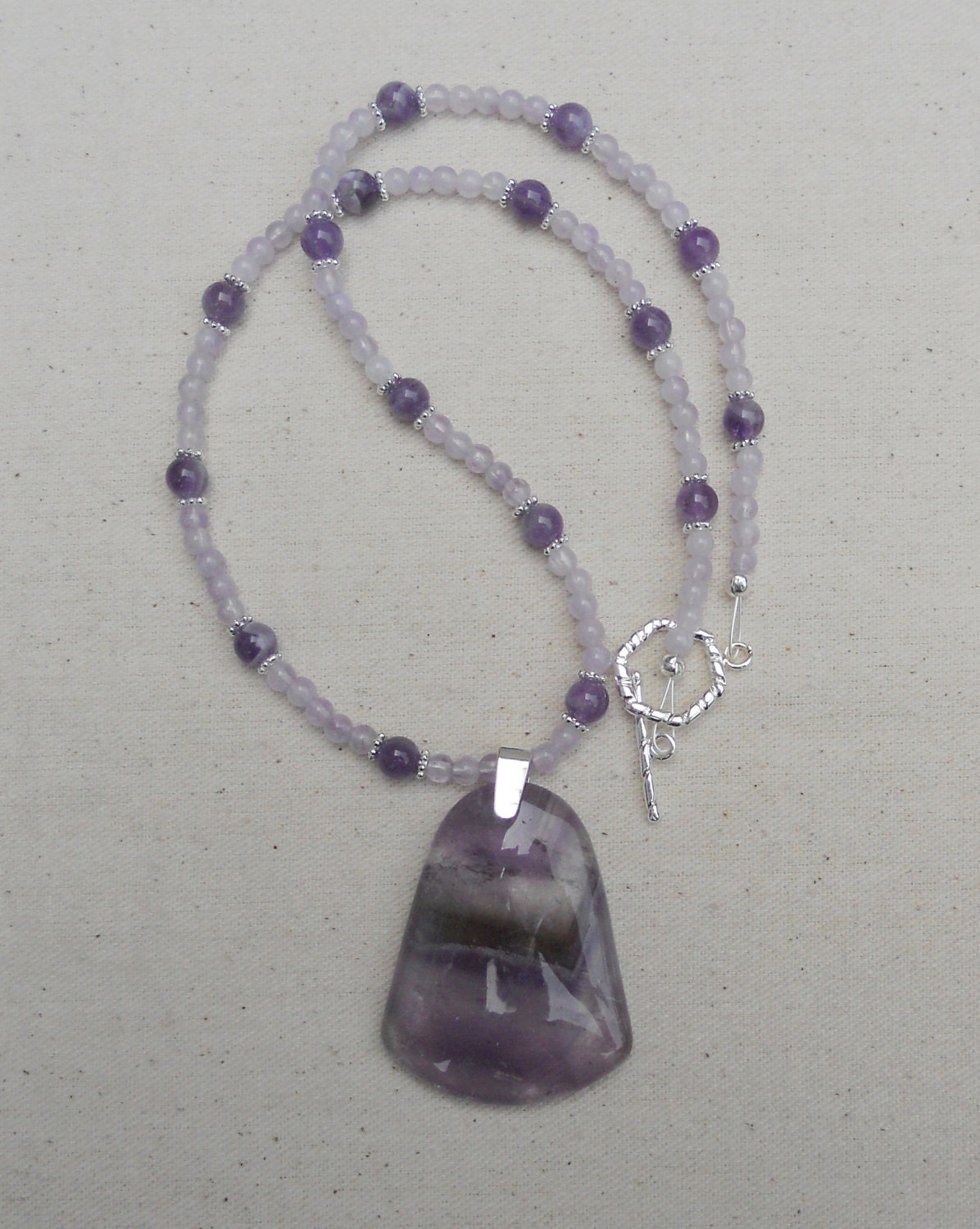 Purple amethyst quartz necklace packaged in a colorful gauze gift bag. J366