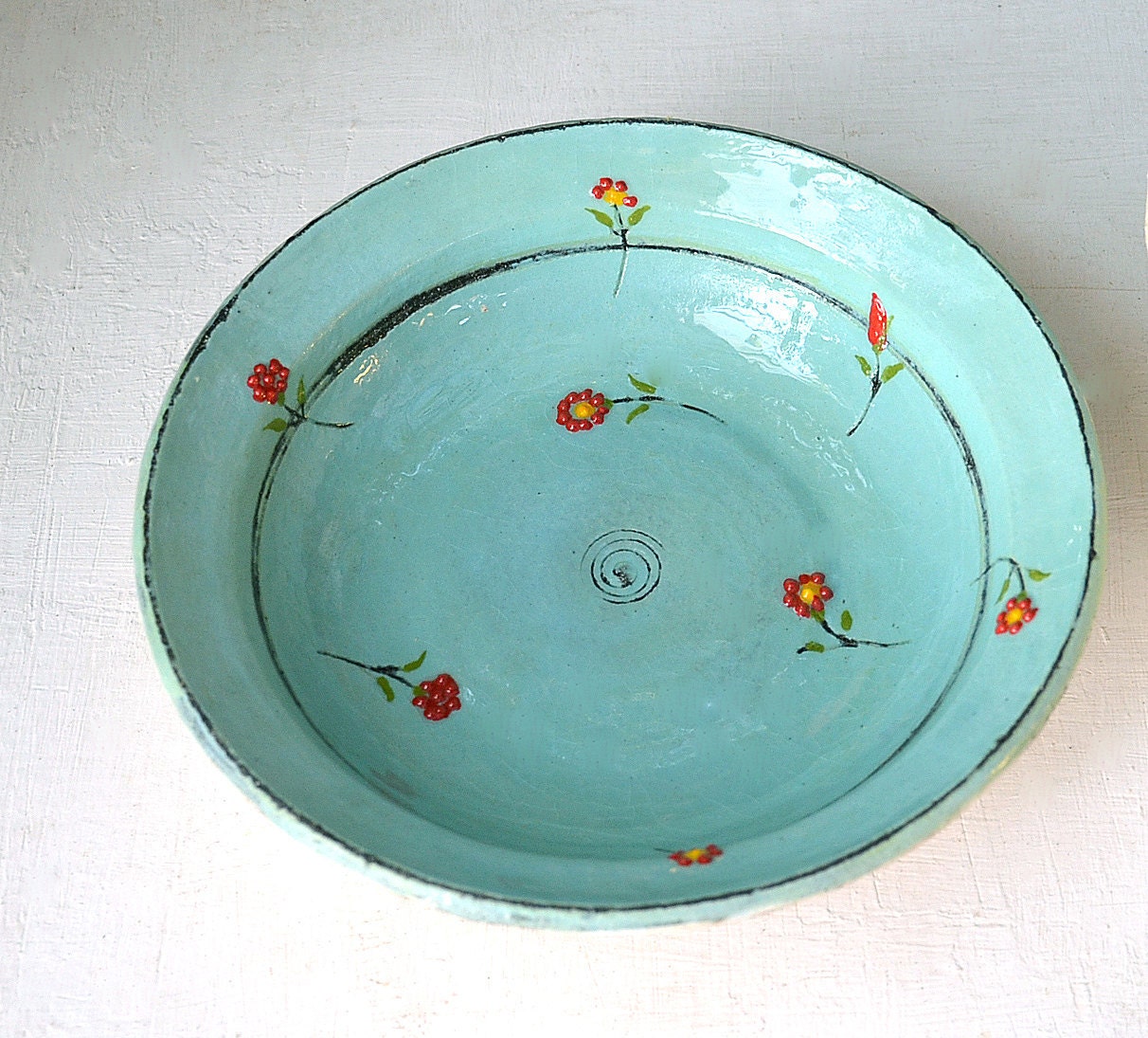 A turquoise- blue bowl with flowers