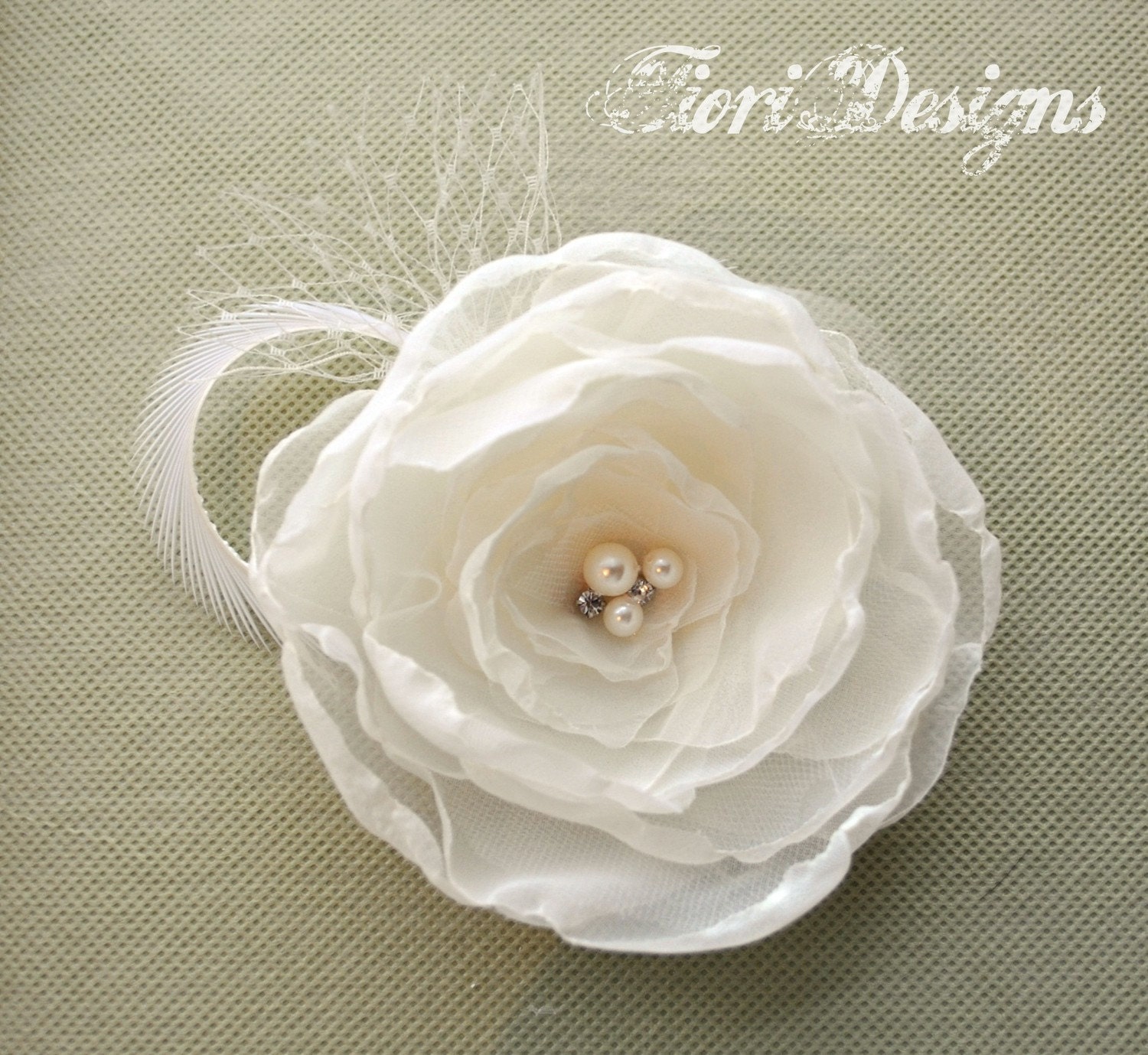 Elegant and sophisticated ivory flower hair clip/facinator accented with french netting and a single feather