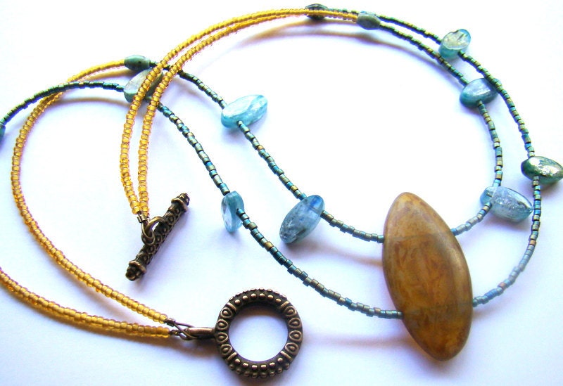 Multistrand beaded statement necklace with caramel focal bead in gold and aqua