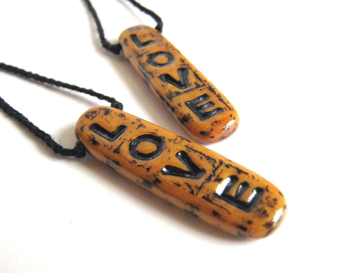 Shimmering sunny yellow golden typographic polymer clay art pendant that spells out L-O-V-E in a distressed urban black finish