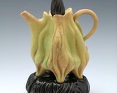 Carved porcelain teapot in green & brown with black lid and pillow