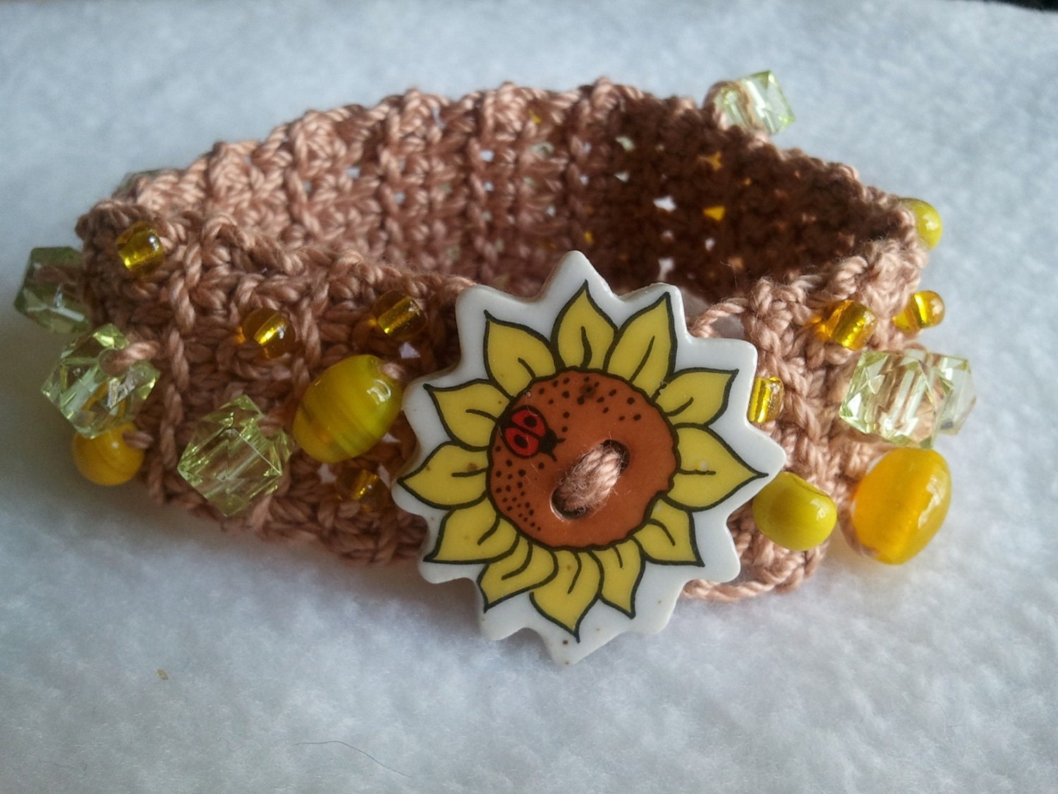Cotton thread crochet bracelet with yellow tone glass beads and sunflower button closure