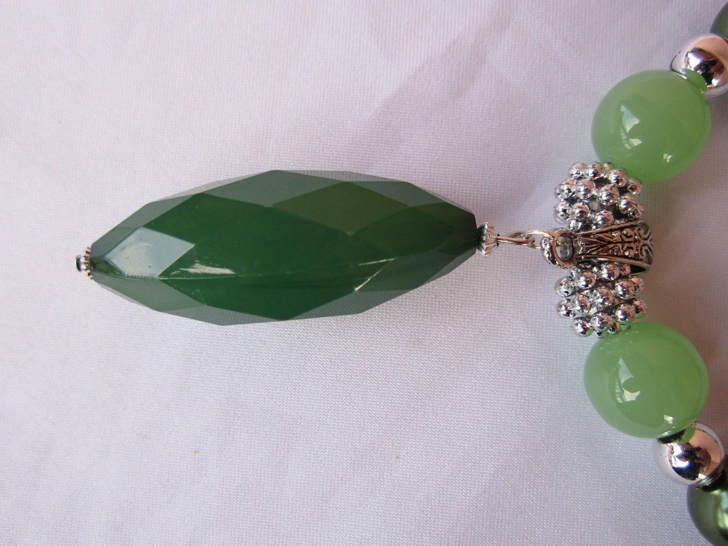 Forest green acrylic oval beaded pendant with jade, olive, yellow with black and silver accent beaded necklace and matching earrings..