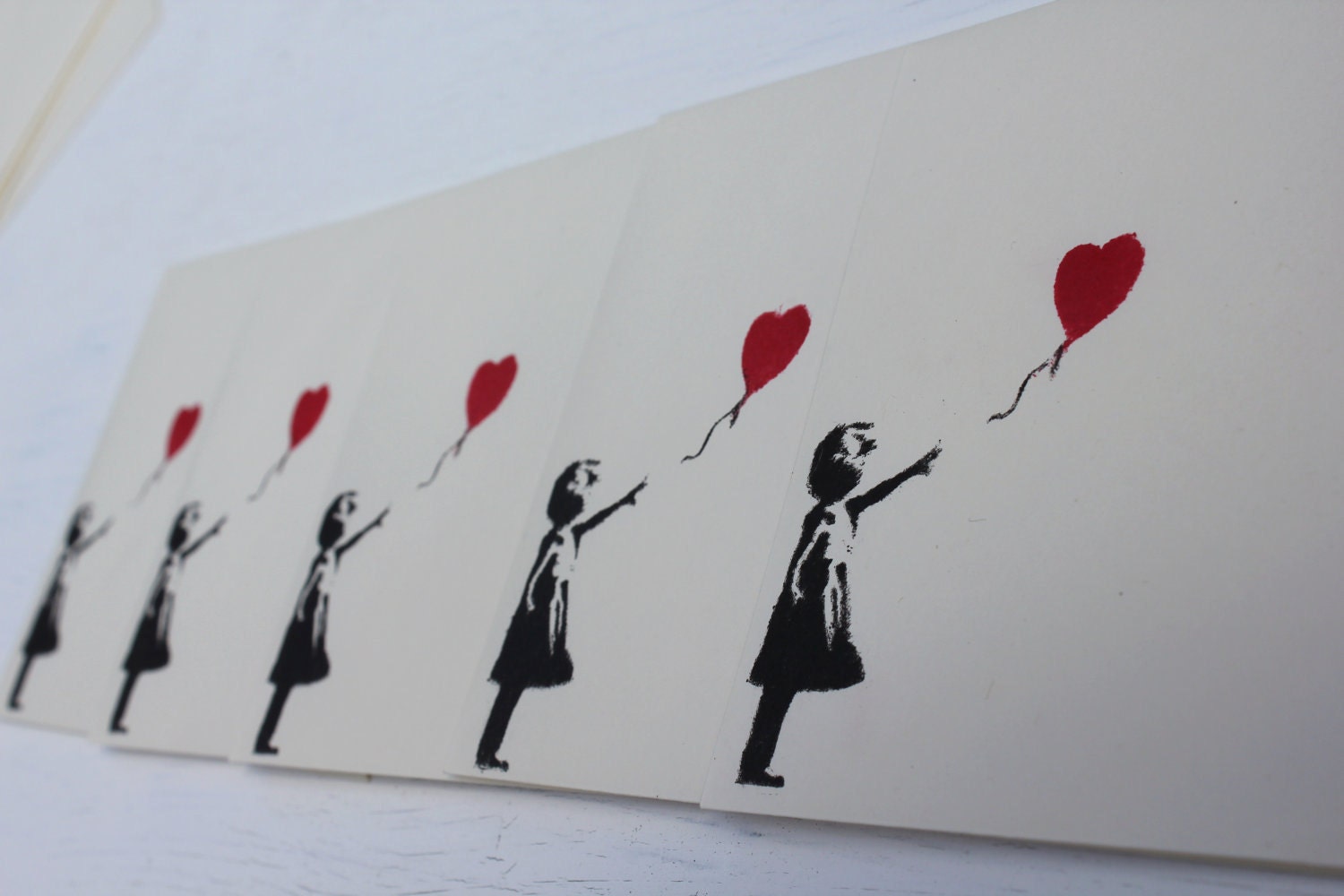 Five 5 ivory pastel envelopes, with red and black loveheart balloon girl on the front. Banksy style. cream stationary