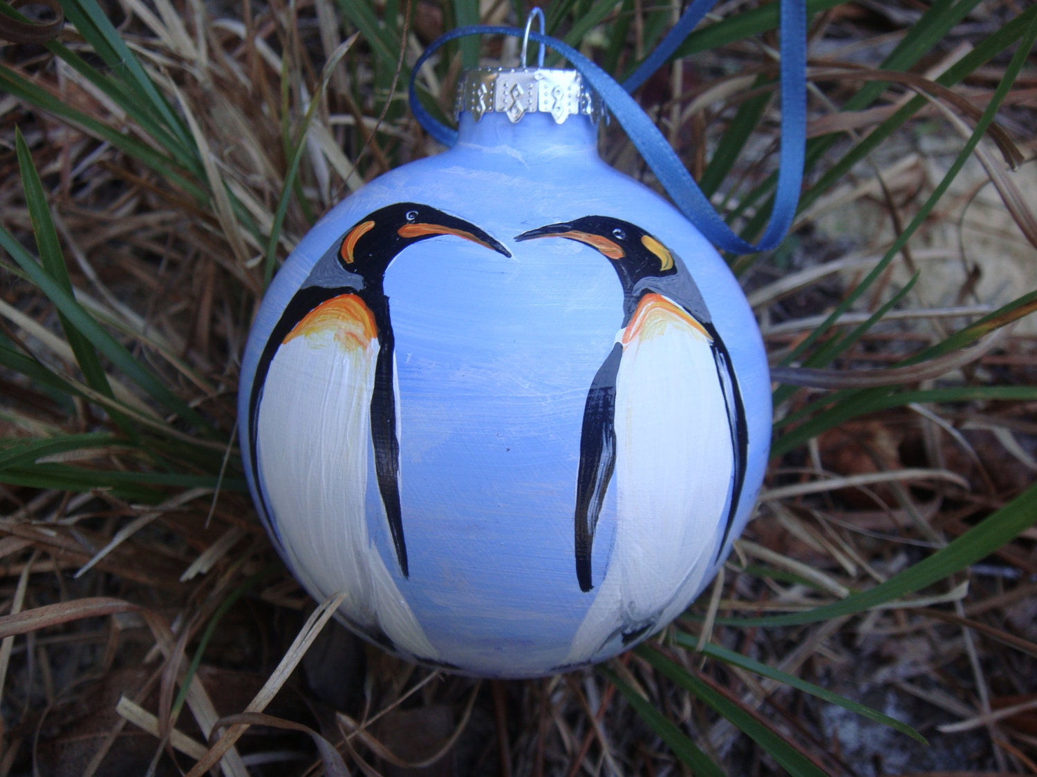 Hand painted glass ornament with penquins