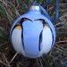 Hand painted glass ornament with penquins