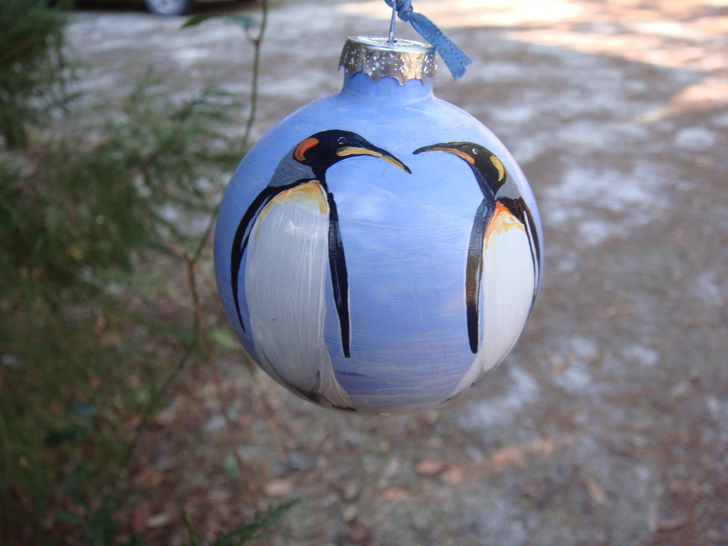 Hand painted glass ornament with penquins