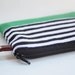 wristlet clutch in black and white strip with green bottom