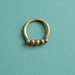 Golden row of tiny skulls ring