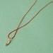 Silver hand on red silk cord