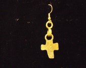 single cross earing with strange designs stamped in it.