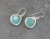 Aqua blue glass framed silver earrings.