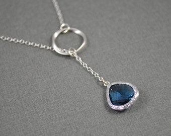 Elegant rhodium plated twristed circle and navy blue stone necklace.