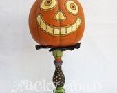Cheesy Grinning Halloween Pumpkin Decoration On Painted Candlestick Stand
