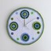 Crochet wall clock with blue and green circles and buttons