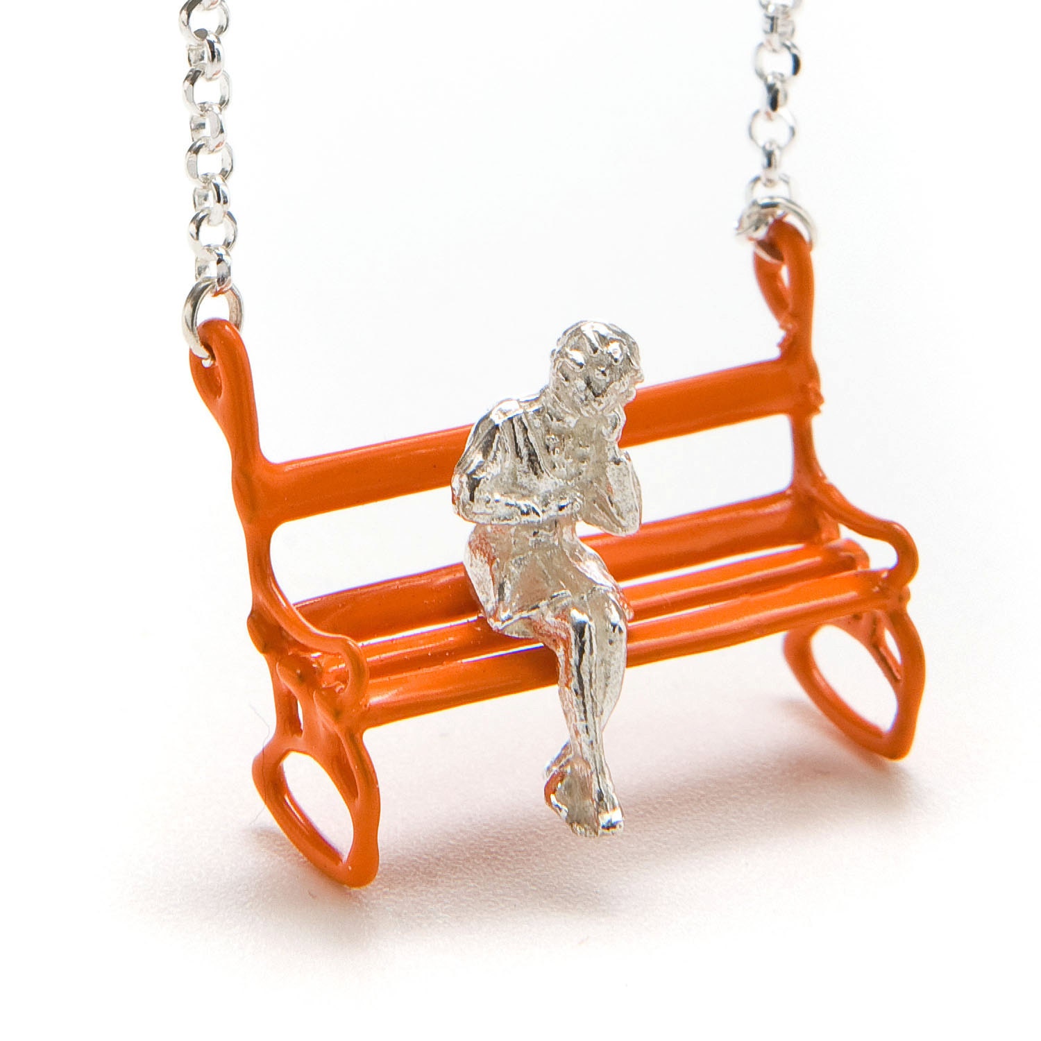 Silver Necklace with a nice Girl who is sitting on an Orange Bench