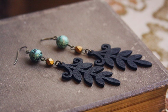zara.  a pair of black wooden leaf earrings.