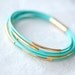 Resreved for Monica T: Mint Green Leather Bracelet with 6 Golden tubes by pardes israel