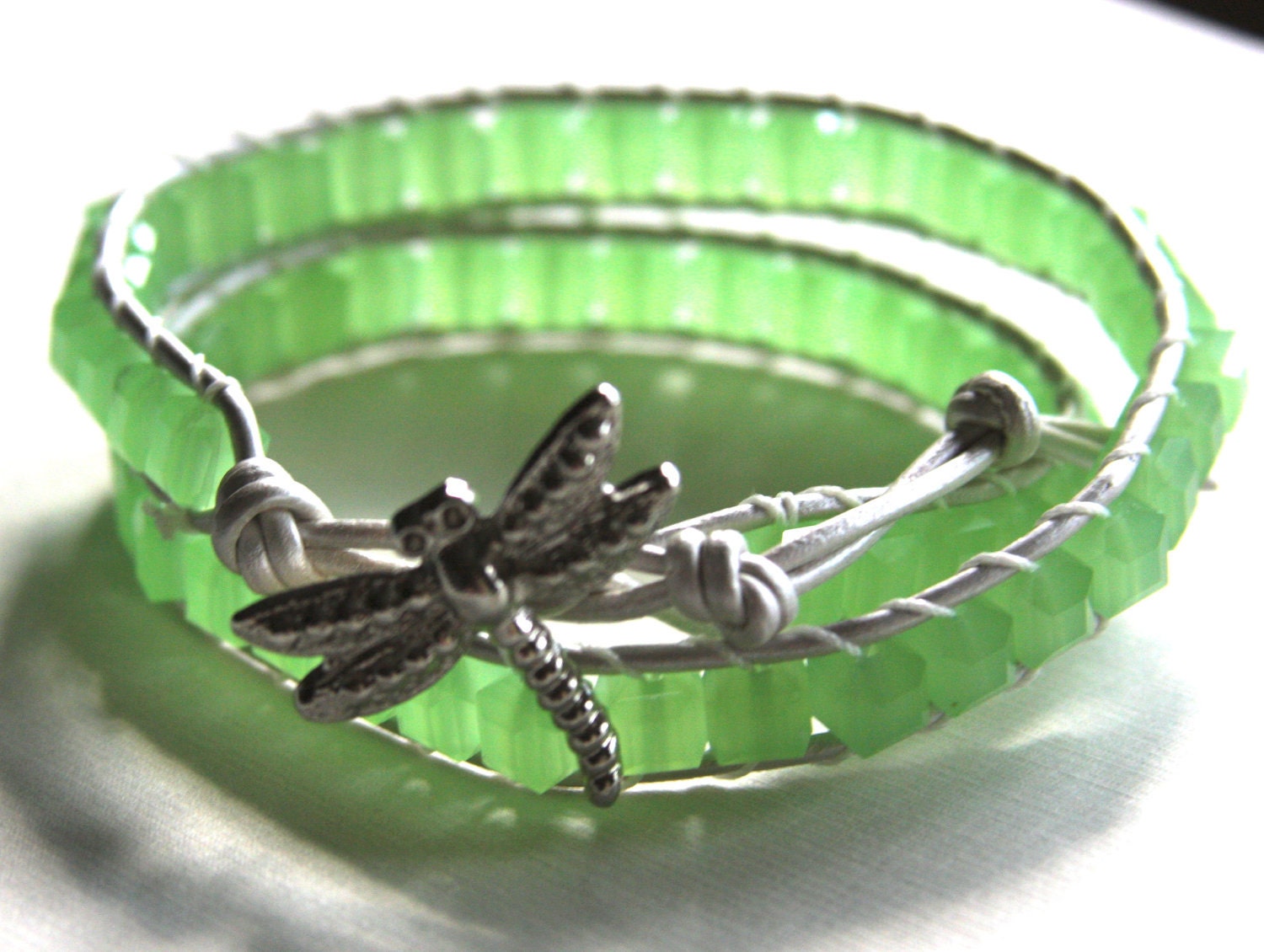 Leather wrap bracelet made with pearl colored leather, lime green cube crystals and silver dragonfly button clasp
