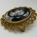 Black glass carved vintage cameo with ornate gold trim