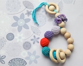 Teething toy rattle with crochet wooden beads and 3 wooden rings. Lilac, teal, lavender, red.