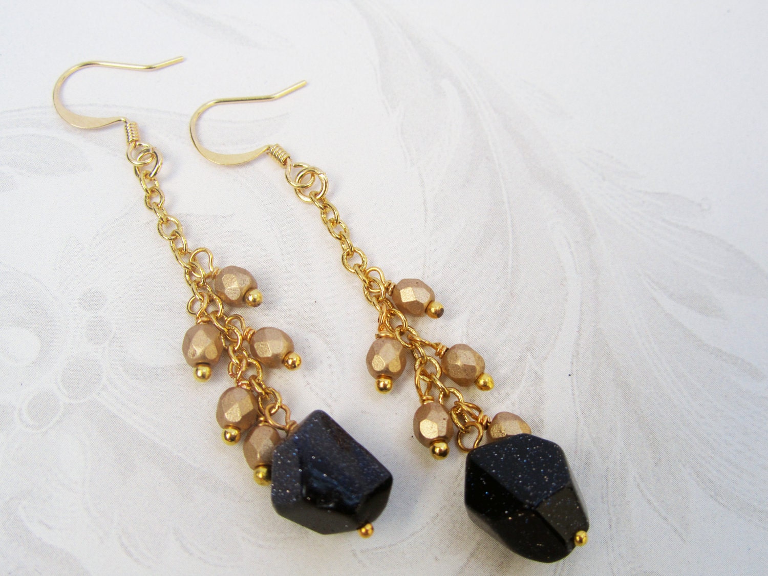 Boho earrings from deep blue goldstone on gold plated chain with dangly gold beads