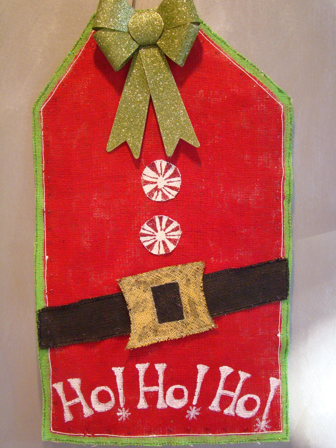 Santa gift tag hand painted burlap door/wall hanging in christmas red and embellished with burlap belt, candy buttons and glitter bow