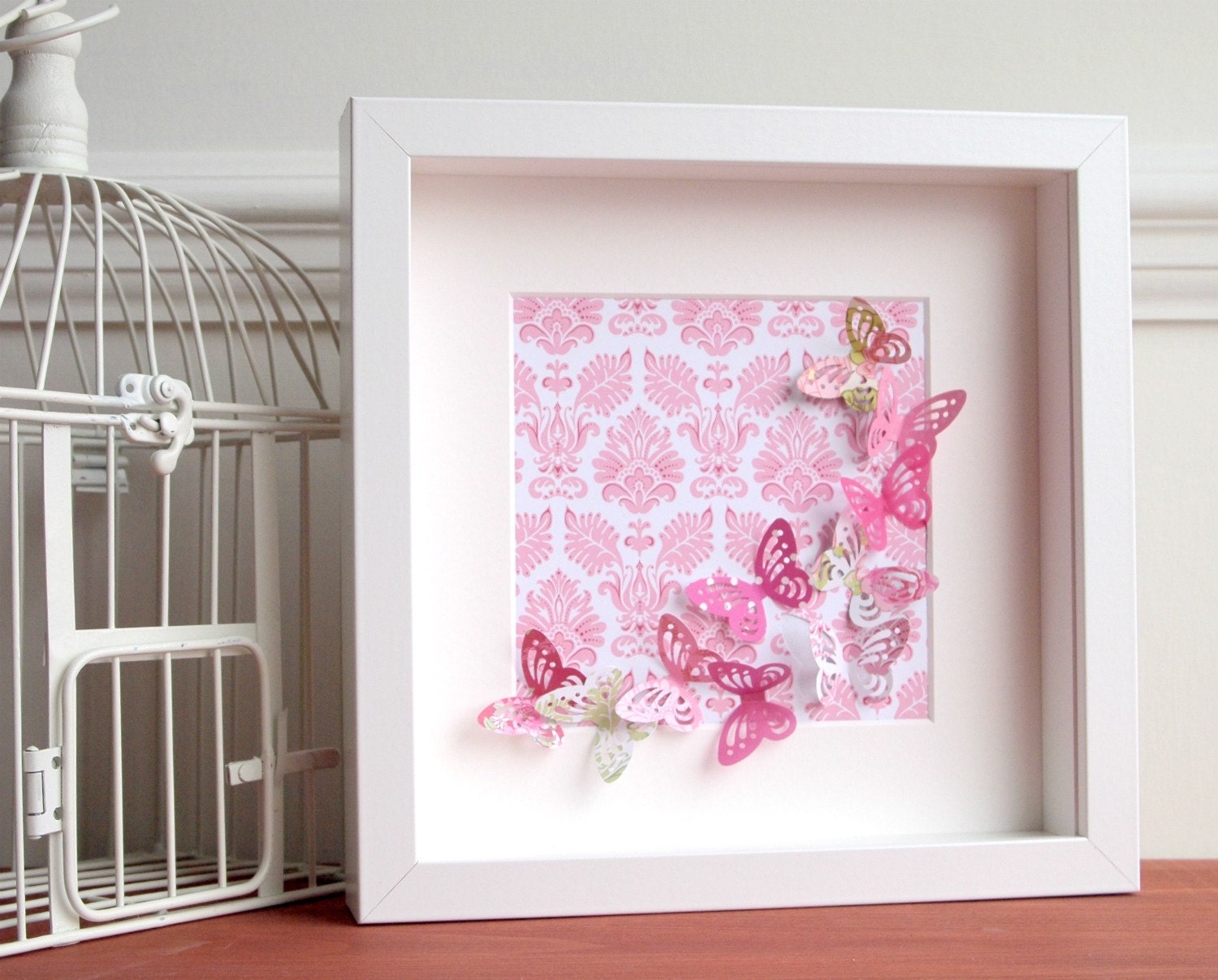 Pink springtime fluttering butterflies in white box frame