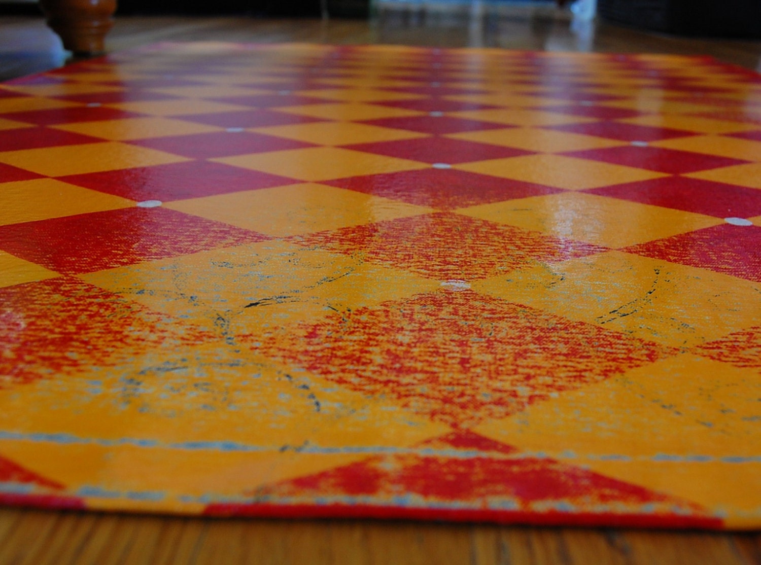 red and yellow diamond floorcloth with blue and black swirl sublayer, canvas art for your floor