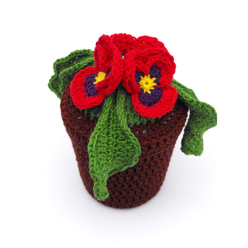 Faux floral arrangement of red & violet pansy flowers in a brown pot