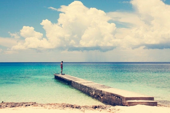 Beach landscape in Maria la Gorda, Cuba. Sunny and lighty day with a calm sea. Lonely man on wooden bridge. 8x10 photograph.
