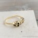 tiny gold skull heads ring