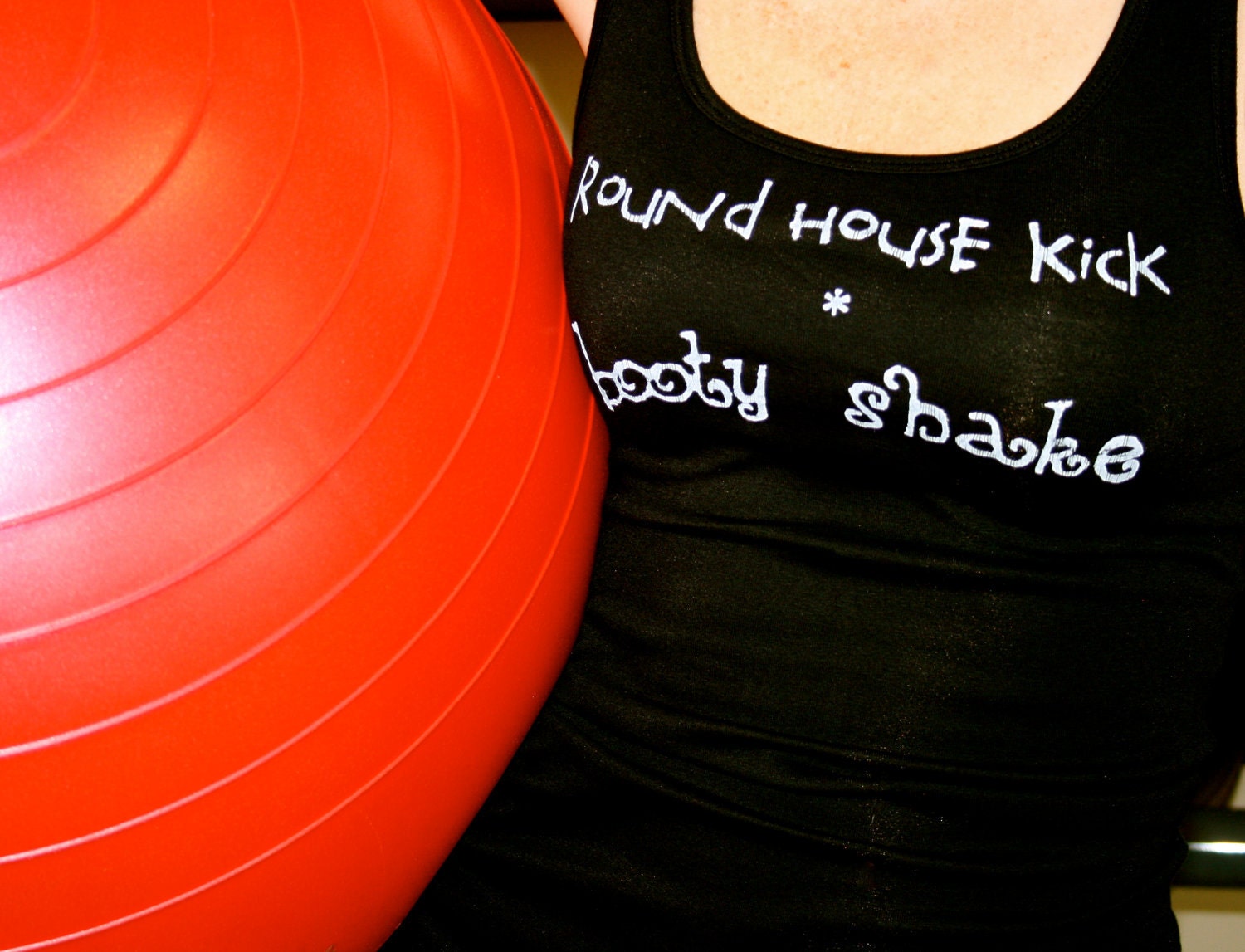 Round House Kick Booty Shake done in vintage looking silk screen on a black workout tank top with lace up back