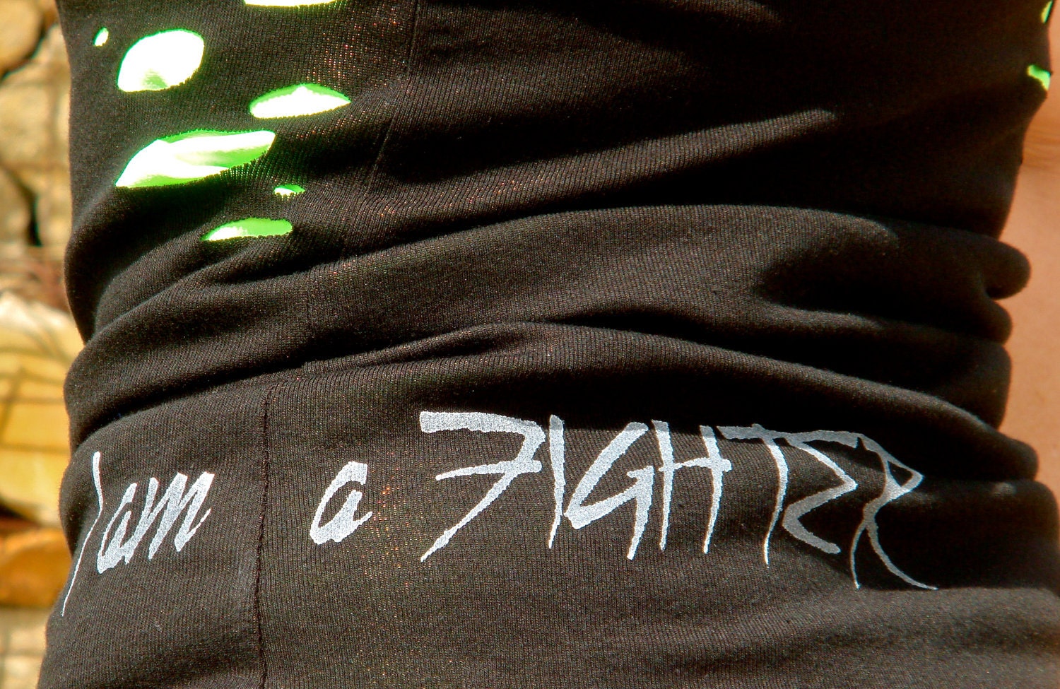 I Am A Fighter done in vintage looking silk screen on a workout black tank top with a random hole front and back
