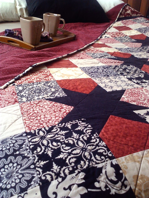 Queen size Sawtooth Star quilt in rich red, black, and creams.