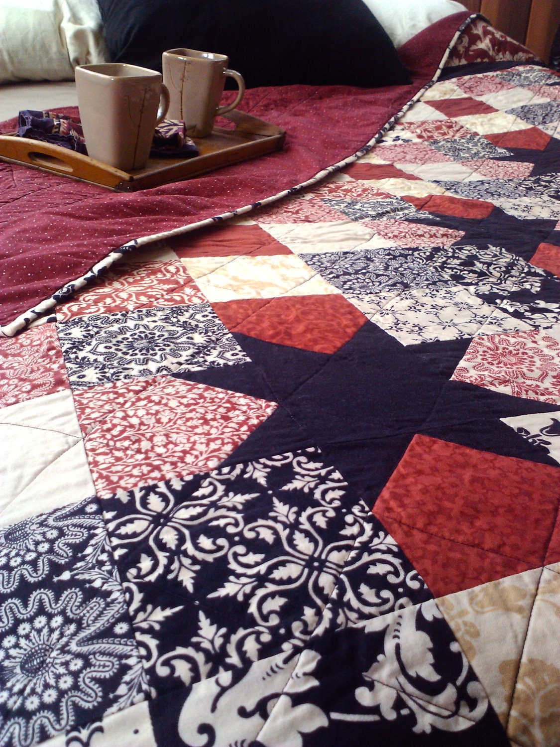 Queen size Sawtooth Star quilt in rich red, black, and creams.