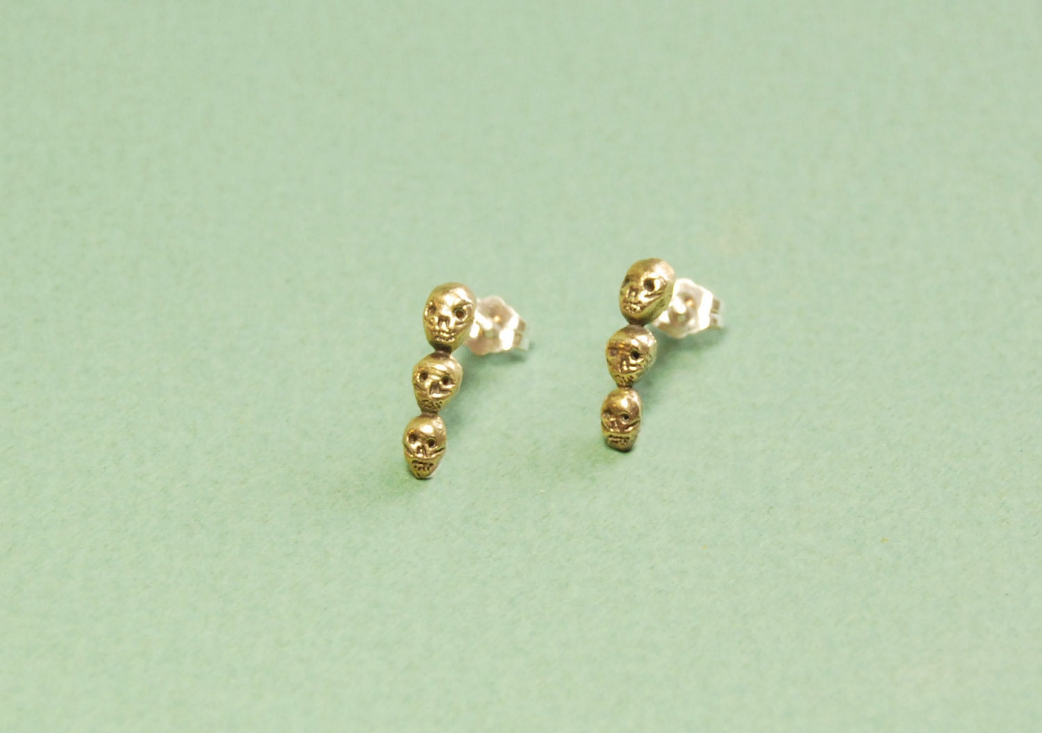 Golden trio of tiny skulls drop earrings