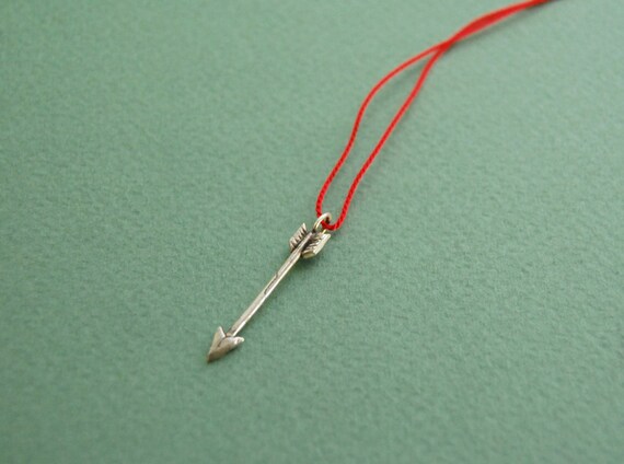 Silver arrow pendant on red silk cord