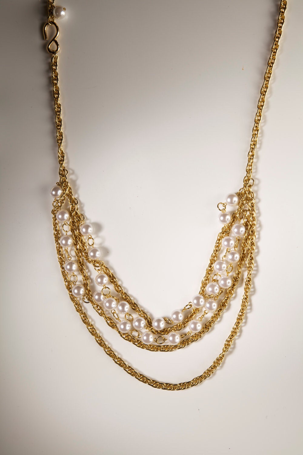 Super stylish dangly gold and faux pearl necklace. Raise the the class level of your casual or fancy outfit.