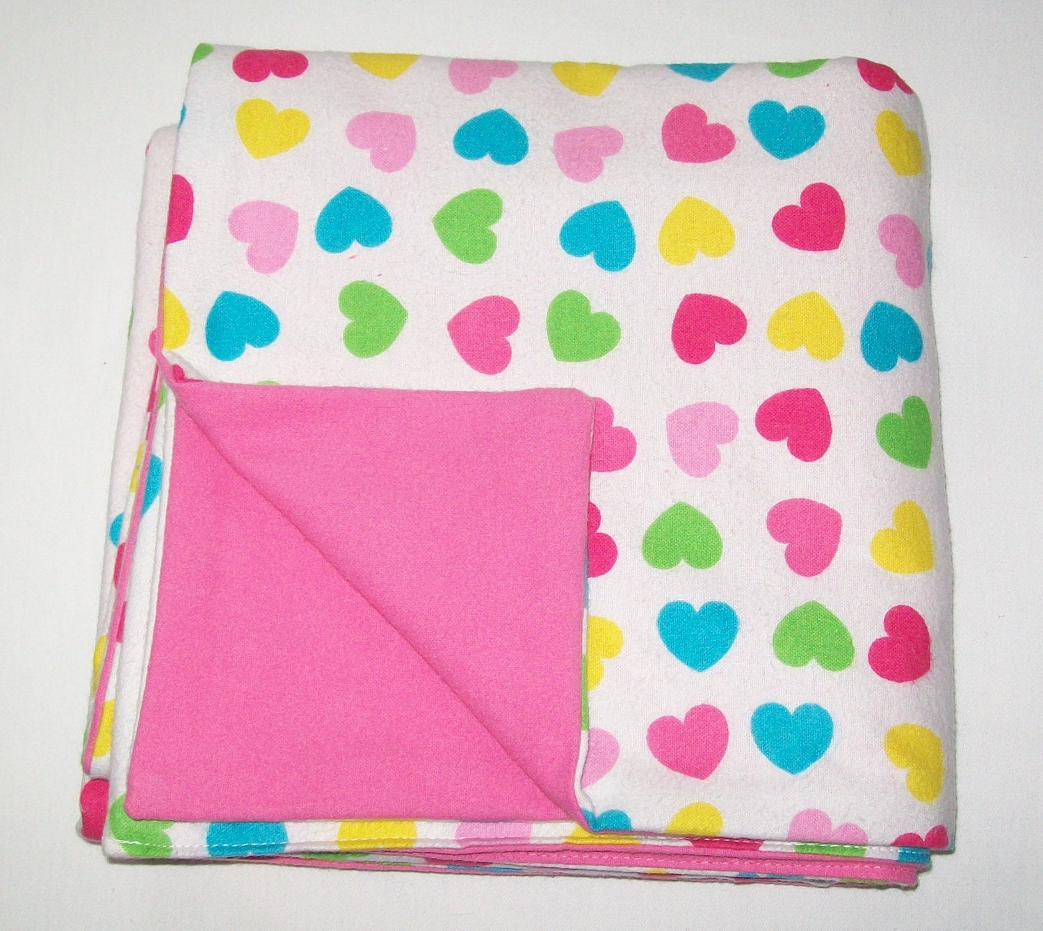 Lively rainbow hearts flannel baby blanket with deep rose color backing
