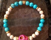 Pink skull bracelet with turquoise and howlite beads.