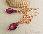 Polished bronze earrings with a squiggle link and purple twisted glass oval beads