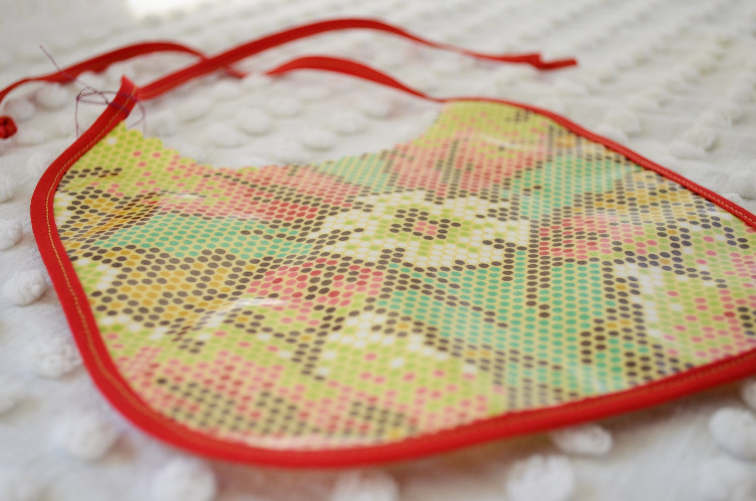 Baby Bib made from Laminated Fabric Mosaic floral print red seam binding