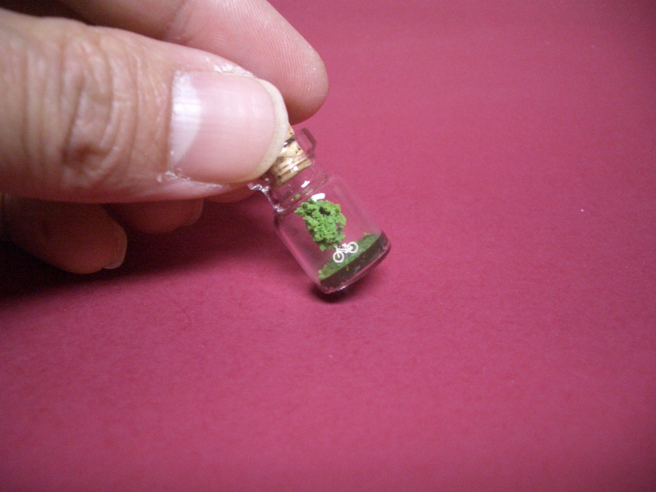A tree and a white bike in a tiny bottle