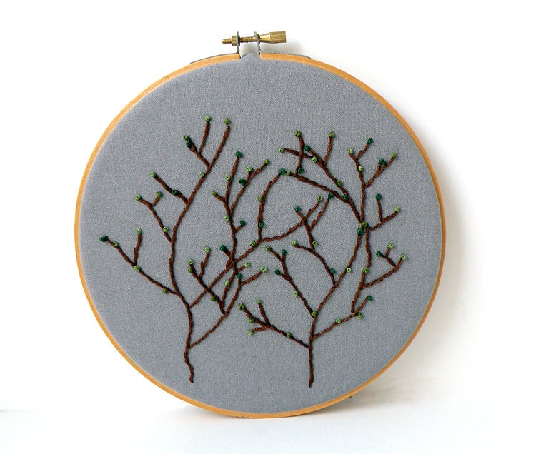 Two brown embroidered trees with green buds on grey cotton wood embroidery hoop wall art