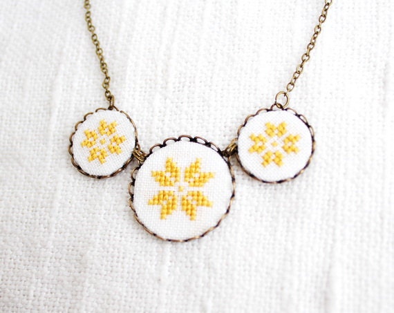 Cross stitch necklace with three yellow ethnic ornament in bronze