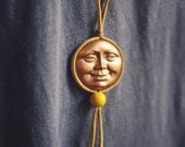 sunshine.  a yellow deerskin wrapped sun face necklace.