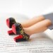 Louboutin shoes bookmark with golden glitter. Legs in book. Elegant black high fashion gift. Gold and red shoes for her